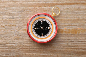One compass on wooden table, top view