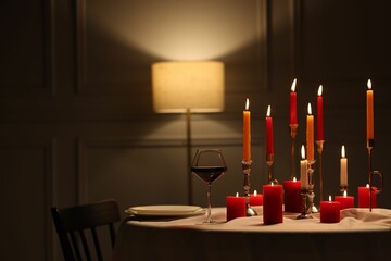 Elegant table setting with burning candles in restaurant