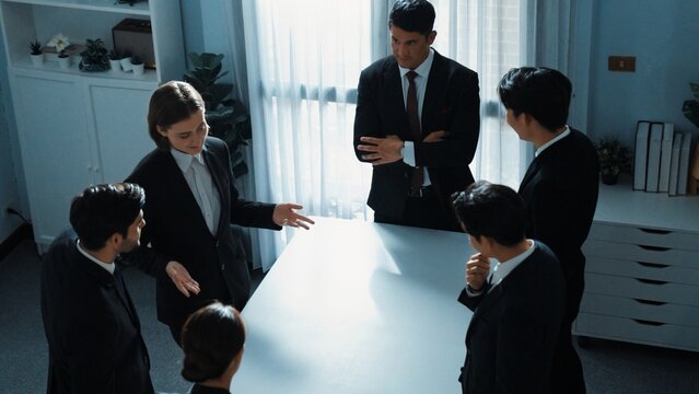 Top view of project manager looking at meeting table surrounded by diverse business people brainstorm and planning strategy. Group of smart people discussing and solve business problems. Directorate.