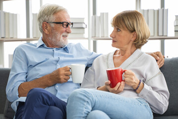 A simple day of a retired couple. Mature couple sitting in the living room and drink coffee.