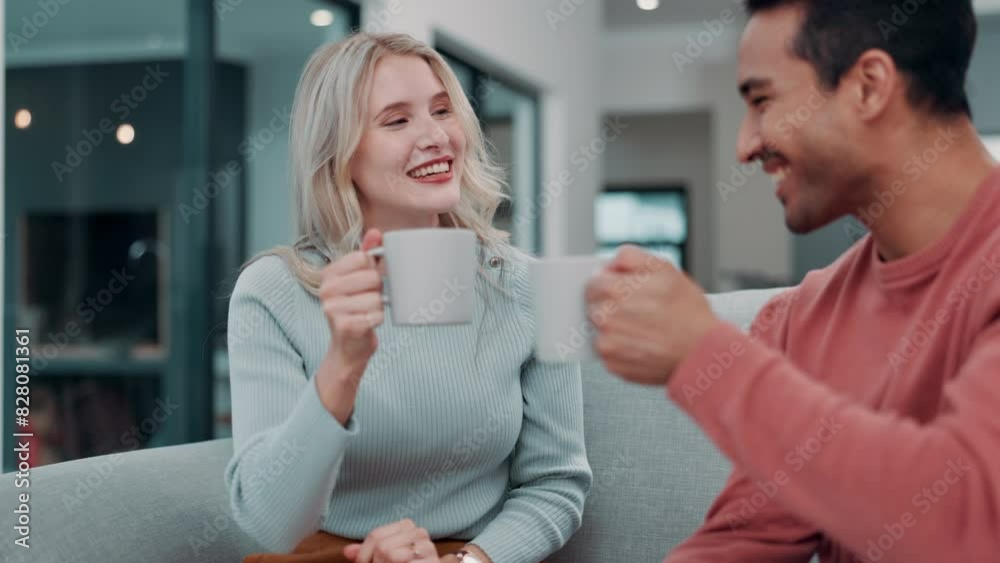 Wall mural Happy couple, talking and drinking coffee in home living room for bonding, cheers or smile together. Man, woman and toast with tea for celebration, conversation or interracial people relax on sofa