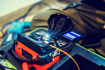 Selective focus to fiber optic splicing cable tools. Fixing Internet Cable. Technician is welding...