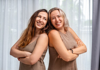 Fototapeta premium Portrait of adult sisters near the window