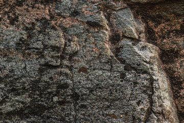 Dark red orange brown stone with cracks Closeup of uneven mountain surface