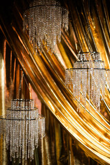 Beautiful abstract golden background with glass crystal chandeliers. 
