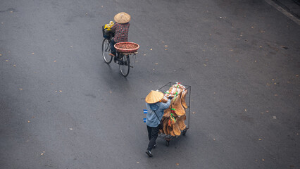 Aerial view street vendor pushing a cart of snacks, cyclist passes a quiet road