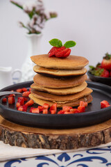 Stack of pancakes hotcakes with honey and strawberries breakfast food american style