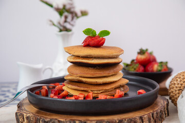 Stack of pancakes hotcakes with honey and strawberries breakfast food american style