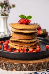 Stack of pancakes hotcakes with honey and strawberries breakfast food american style