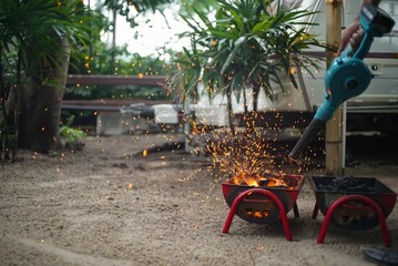 Use a blower to blow the charcoal until it ignites and sparks come out