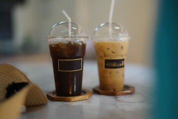 two plastic glasses of coffee on the table