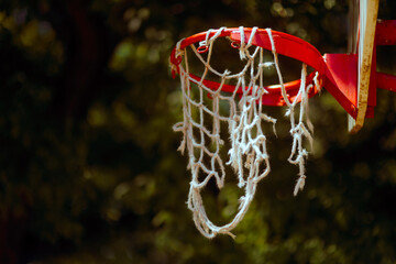 Broken basketball hoop on an outdoor court. Detail of a damaged sports court from a small town
