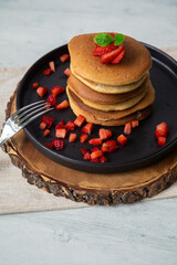 Stack of pancakes hotcakes with honey and strawberries breakfast food american style