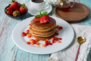 Stack of pancakes hotcakes with honey and strawberries breakfast food american style