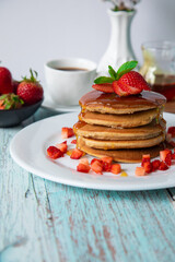 Stack of pancakes hotcakes with honey and strawberries breakfast food american style