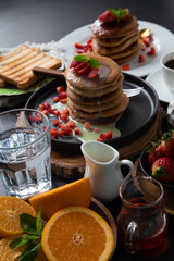 Stack of pancakes hotcakes with honey and strawberries breakfast food american style