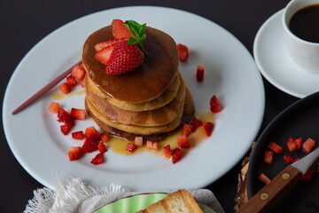 Stack of pancakes hotcakes with honey and strawberries breakfast food american style