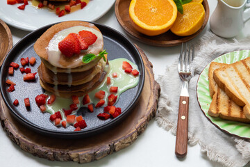 Stack of pancakes hotcakes with honey and strawberries breakfast food american style