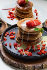 Stack of pancakes hotcakes with honey and strawberries breakfast food american style