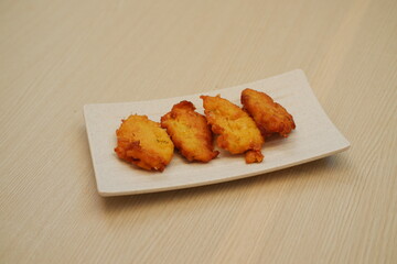 Corn croquettes on a white plate on a wooden table