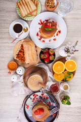Breakfast table full of food brunch pancakes, bread and fruit