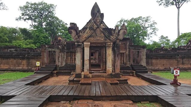 Wide Shot stabilized camerad track to Banteay Srey Temple near Angkor Wat temple complex near Siem Reap, settle on lintel top piece