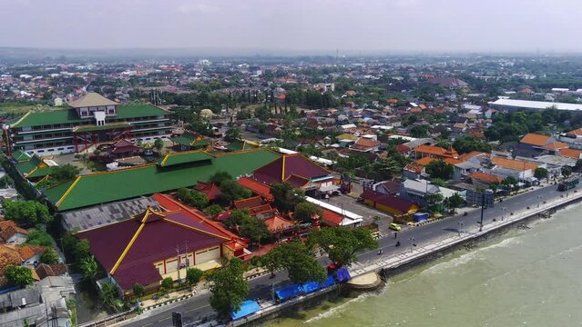 a city along the Tuban coast line in East Java, with houses lining the beach and boats bobbing in the ocean.