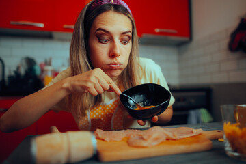 Woman Beating Eggs with Fork Preparing a Homemade Schnitzel. Funny girl trying to make a recipe at...