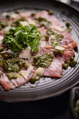 tuna carpaccio - slices of fresh raw tuna fillet on black ceramic plate
