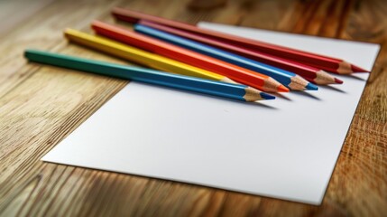 Obraz premium Colorful pencils with a blank sheet of paper on a wooden surface