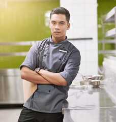 Asian man, portrait and chef with arms crossed in restaurant kitchen for professional cooking,...