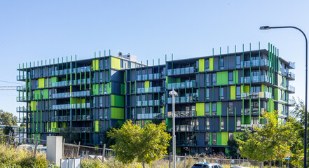 A funky modern accommodation building containing residential apartments in shades of green and...