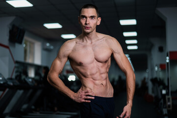 Obraz premium Shirtless man with sculpted body in the gym. 