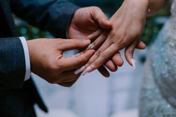 The bride and groom holding jewelry together, symbolizing unity and shared commitment.