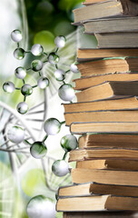 stack of books and stylized DNA models on a green blurred background