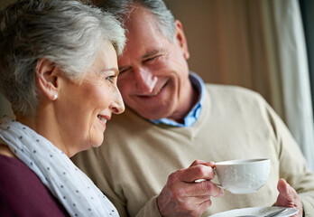 Senior couple, tea and window in home for relax, love and drink for married man and woman. Living...