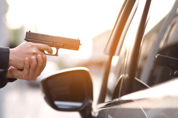 Thieves are using guns to rob a car, threatening a woman with car keys. - Powered by Adobe