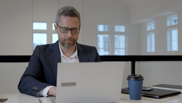 Office worker with laptop at office. Ofice employee remote working in modern office. Businessman have on line meeting. Business man using computer in office. Modern offices workplace.
