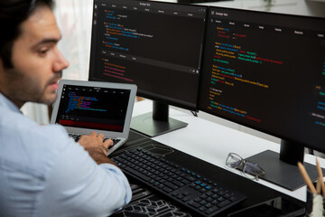 Concentrating in smart IT developer working software development coding on laptop and pc, creating...
