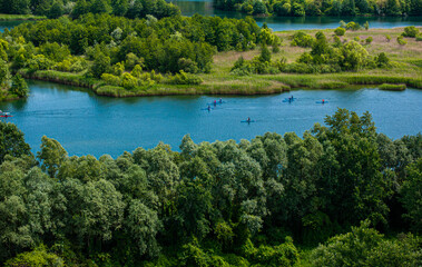 Athletes training in kayaking and canoeing. Aerial photo with a lot of athletes on a river lake practicing for their sport kayak and canoe.