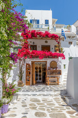 Traditional Cycladitic alley with a narrow street with a full blooming bougainvillea in Mykonos...