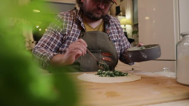 a male chef makes kutab dough in a home kitchen
