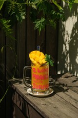 A glass of champagne, filled with sparkling bubbles, stands next to a vibrant red rose. The delicate petals of the rose contrast beautifully with the crystal clarity of the champagne, exuding elegance