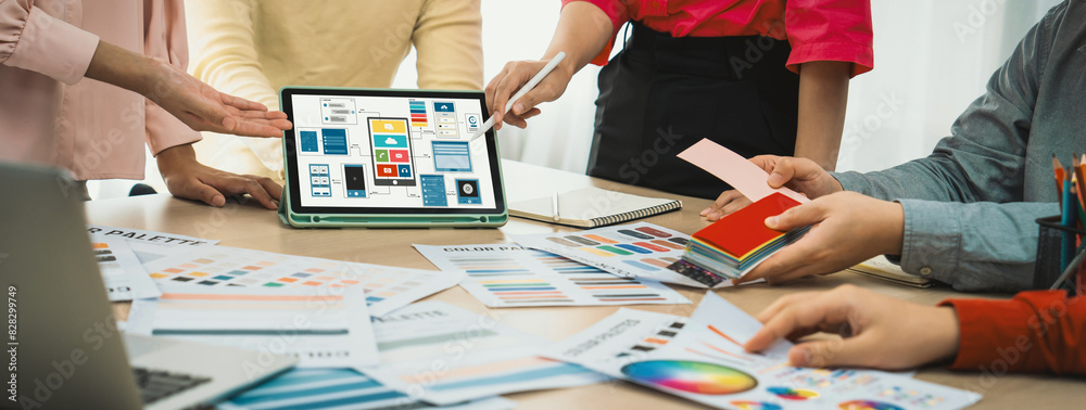 Wall mural cropped image of interior designer team chooses color from color swatches while tablet displayed ui 