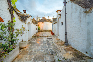Trulli of Alberobello, Puglia, Italy. town of Alberobello with trulli houses among green plants and...