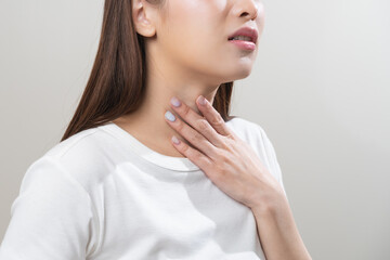 Sickness in inflaming asian young woman, girl use hand check self touch at sore throat, pain...