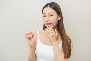 Lip care protection concept, asian young woman, girl applying balm from jar, taking with finger,...