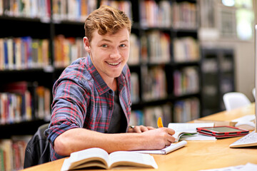Student, portrait and notebook in library for study, education and university quiz with pen on table. Man, happy and books on school campus for college exam, research and learning with scholarship