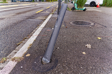 Close-up of smashed and bent gray metal pole at pavement at Swiss City of Z&uuml;rich on a cloudy autumn day. Photo taken November 3rd, 2023, Zurich, Switzerland.