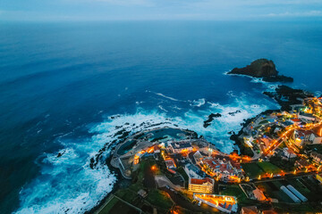 Aerial view of Porto Moniz with volcanic lava swimming pools, night city,  Madeira, Portugal